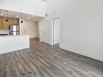an open kitchen and living room with wood flooring